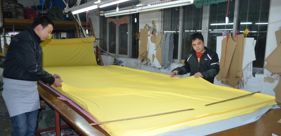 裁床师傅在认真做铺布工作,然后进行裁剪